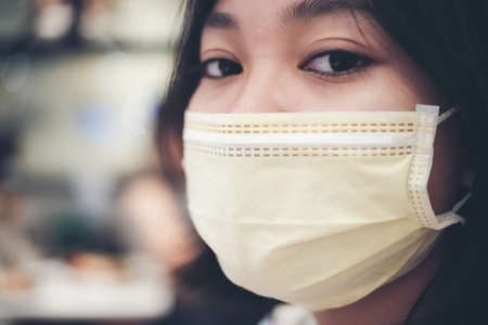 An Asian female teenager wears a surgical mask to protect against a new strain of viruses.の写真素材
