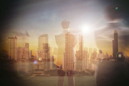 Business people standing and looking back at the business city.This image is double exposure soft focus background.の写真素材
