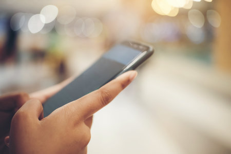 The hand of a woman using a smartphone.This Image is soft focus.