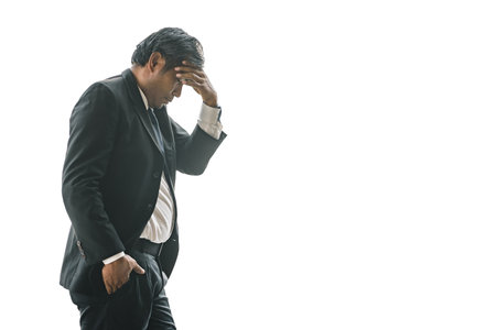 An elderly business man is worried and stressed about his problem on a white isolated background.