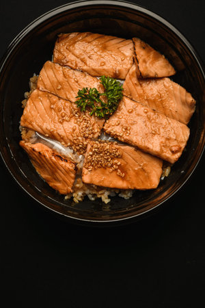 Japanese food, salmon teriyaki with rice on black background.の写真素材