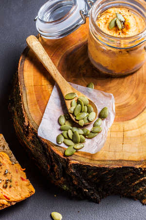 A slice of grainy bread with homemade pumpkin puree, on a woodの写真素材