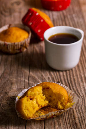 pumpkin muffins and a cup of coffee on a wooden tableの写真素材