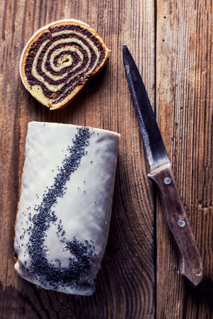 Slice of poppy seeds cake and a wooden knifeの写真素材