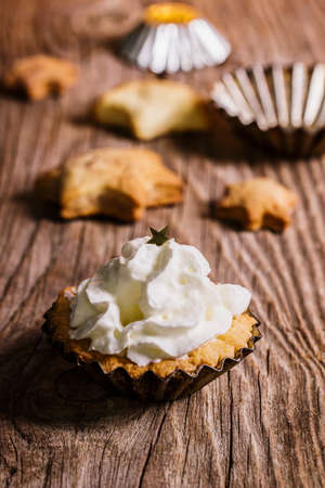 Brittle cookies in steel moulds with cream on the topの写真素材