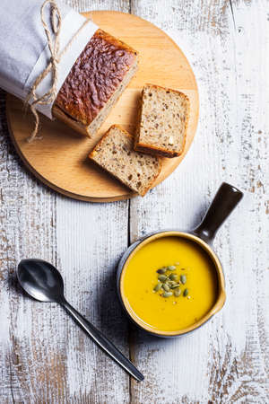 Pumpkin soup with bread on a white rustic table view from topの写真素材