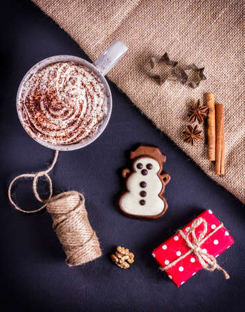 Hot cocoa, presents, gingerbread and cinnamon on a dark backgroundの写真素材