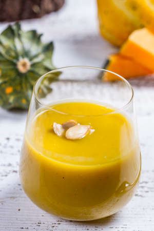 pumpkin soup in a glass on a wooden rustic tableの写真素材