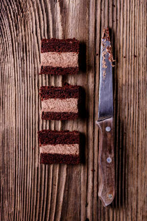 Slices of homemade chocolate cake on a wooden tableの写真素材