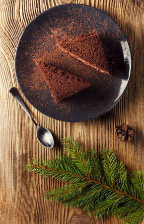 Chocolate cake with cream on a wooden tableの写真素材