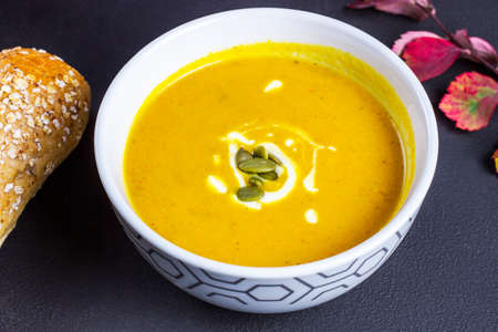 Bowl of pumpkin soup and breadの写真素材
