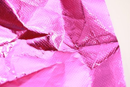 abstract textured pink crumpled shiny backgroundの写真素材