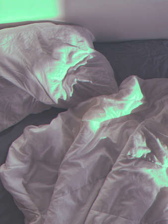 background romantic aesthetic photo. crumpled blanket and pillow in sunlightの写真素材