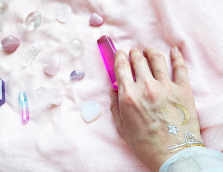 beautiful esoteric magical background. the magician's hand holds, selects the necessary crystals and...