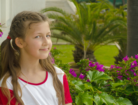 Little adorable girl smelling colorful flowers at summer dayの写真素材