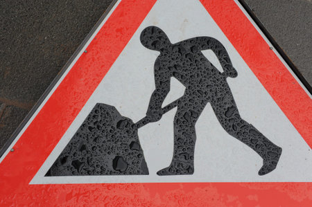 man at work sign under rain drops