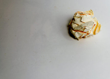 One yellow crumpled ball on a white background - High res image
