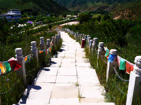 The Tibetan Buddhism in the deep mountains, "Five Dangzhao", is called the Little Potala Palace, there are ancient buildings, and the sacred hall, the scenery of the mountain road is very beautiful, and the prayer flag tower for people. Bright and beautifulの写真素材
