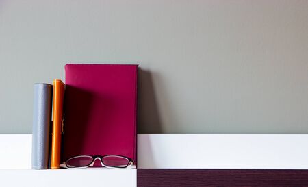 Book, Notebooks and glasses on modern shelfの写真素材
