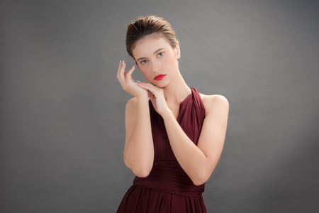 Beautiful woman wearing red dress on gray background for Beauty and spa conceptの写真素材