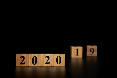 Happy New year 2020 concept with wooden cube change from 2019 to 2020 on black isolate background