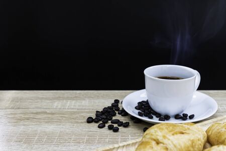 Hot coffee in white cup with coffee bean and croissants on wooden table, Breakfast conceptの写真素材