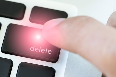 A finger is pushing delete button on keyboard of Laptopの写真素材