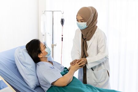 Muslim doctor talking with patient from Covid-19 for encouragement in hospital, Coronavirus recovery conceptの写真素材
