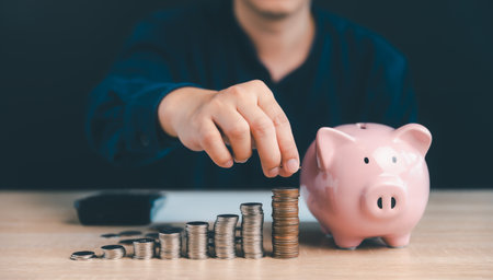 Businessman stacking coins and piggy bank, Money saving and investment growth and Business development concept.の写真素材