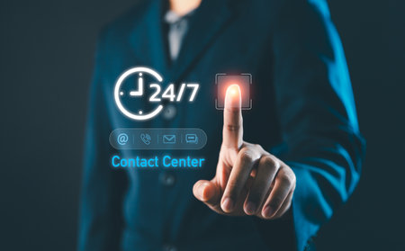 Businessman touching virtual contact center icon with 24 hours and 7 days support symbol, representing digital communication, customer service technology and modern online business solutionsの写真素材