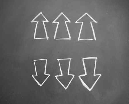 arrows drawn with chalk on blackboardの写真素材