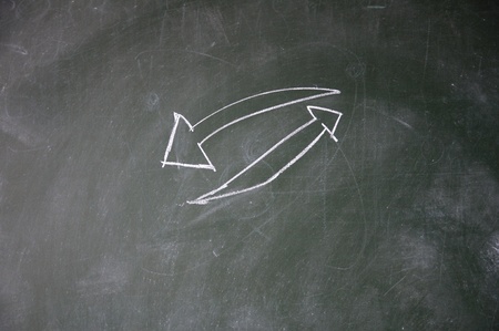 arrows drawn with chalk on blackboardの写真素材