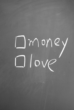 money or love choice written with chalk on blackboardの写真素材