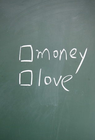 money or love choice written with chalk on blackboardの写真素材