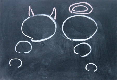 Angels and demons thinking drawn with chalk on blackboardの写真素材