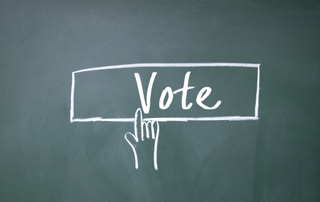 abstract finger click vote sign on blackboardの写真素材