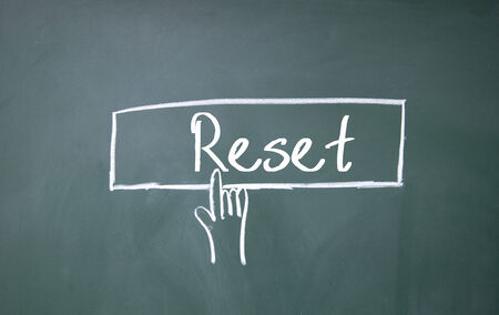abstract finger click reset sign on blackboardの写真素材