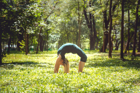 Urdhva Dhanurasana. Yoga asanas in nature. Yoga poses everyday. Practicing young woman. Yoga in the...