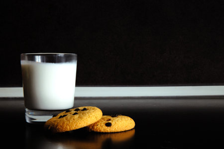 Good morning. Breakfast Cookies and a glass of milk. yogurt. Black background. black and white
