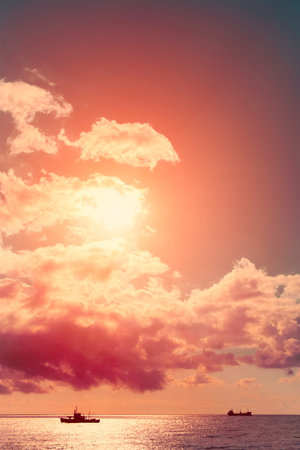 Ships in the sea at sunset. Clouds in golden light