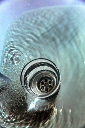 A transparent glass of water stands in the water.の写真素材
