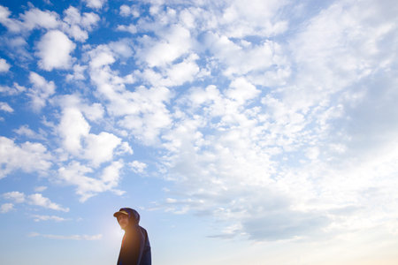 Young attractive man and wide open arms in blue sky view background feeling wind and sunshine. Happy asian hipster male in youth freedom culture travel concept.の写真素材