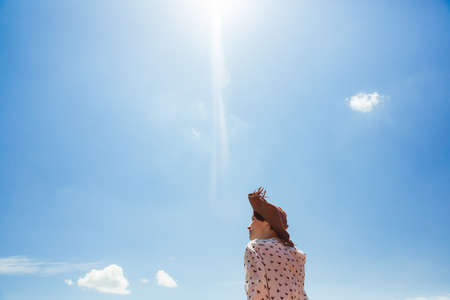 Young Woman in hat enjoying summer time Travel Lifestyle happy emotions outdoor vacations blue sky Smile girl tourist walkingの写真素材