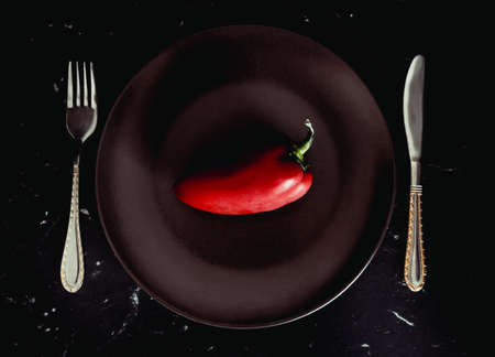 Red bell pepper paprika on a plate. Diet. Dark background.の写真素材
