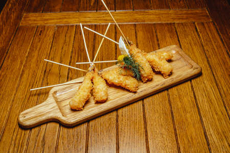 large shrimp in batter on a blackboard on a wooden tableの写真素材
