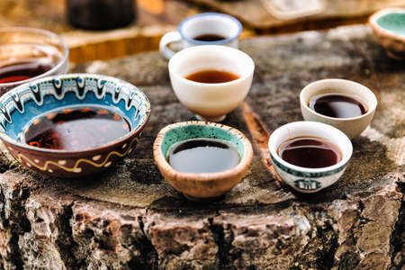 Tea ceremony. Lots of small cups. On an old stump. Health.の写真素材