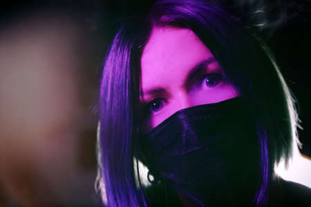 Young woman in a mask. Self-isolation protection at home. Coronavirus. Pink colorの写真素材