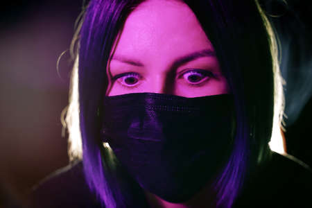 Young woman in a mask. Self-isolation protection at home. Coronavirus. Pink colorの写真素材