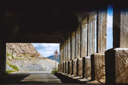 Mountain road . Inside the tunnel with columns. Road signの写真素材