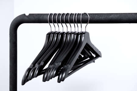 Empty black clothes hangers on a white backgroundの写真素材